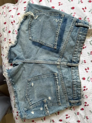 Blå denimshorts från ZARA - Säljer ett par blå denimshorts från ZARA med normal midja, fickdetaljer. 