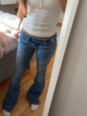 Blå  Lågmidjade bootcut jeans - Säljer mina jättefina Lågmidjade jeans från Gina som är eftertraktade! De är i storlek xs i Gina 14+!💕🙏🏼 Knappast använda och väldigt fint skick!