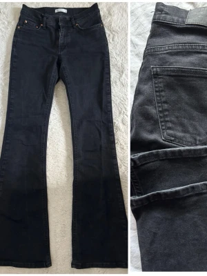 Svarta bootcut jeans med hög midja - Snygga svarta bootcut jeans med hög midja och klassiska fem fickor. Jeansen har utsvängda ben och en stilren look som passar till det mesta. Tillverkade i ett mjukt denimtyg som ger en bekväm känsla hela dagen.