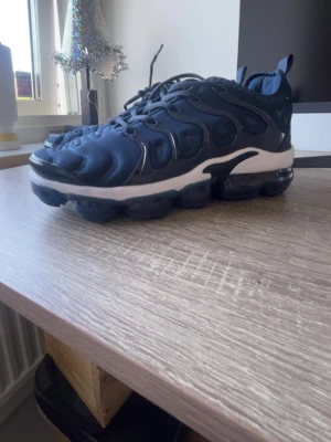 Marinblå chunky sneakers - Säljer ett par marinblå chunky sneakers med svart och vit sula. Skorna har en sportig design med vågiga detaljer på ovandelen och tjock, genomskinlig sula. Perfekta för dig som gillar streetwear och vill ha något som sticker ut.