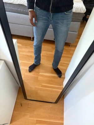 Ljusblå slim fit jeans herr - Säljer ett par ljusblå slim fit jeans med klassisk femficksdesign och normal midja. Jeansen har en snygg tvätt och smal passform som sitter lite lösare än vanlig slim fit men ändå ganska tajt längs benen. Perfekta för dig som gillar en modern och enkel stil. Jag är 194 cm lång och byxorna är lite för små i längden men ok i bredden. Byxorna går bra att bära både i häng men även med vanlig passform. Köpt på Brothers ordinarie pris 1099kr.