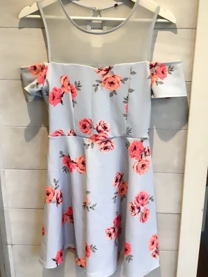 Ljusblå offshoulder klänning med blommor - Supersöt ljusblå kortklänning med rosa och aprikosa blommor. Offshoulder-modell med mesh upptill och korta ärmar. Perfekt till sommaren 😍😍 storlek s-m