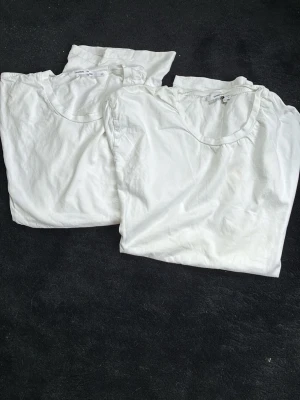 Två vita basic t-shirts från Samso samso - Säljer två klassiska vita t-shirts med rund hals. Perfekta till alla outfits och har en enkel, clean look. T-shirtsen är kortärmade och gjorda i mjukt bomullstyg för skön känsla hela dagen.