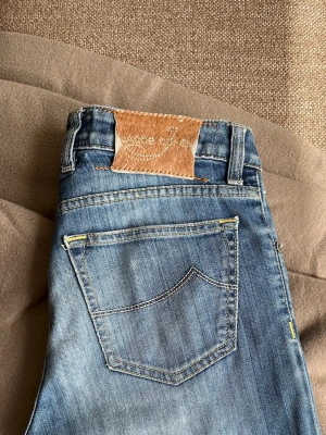Jacob Cohën jeans - Snygga blå jeans från Jacob Cohën i modellen 622 Comfort. Jeansen har klassisk femficksdesign, ljus tvätt och detaljerade sömmar. Tillverkade i mjukt denim med knappgylf och läderpatch bak i midjan. Perfekta för en avslappnad och trendig stil.