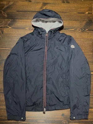 Moncler Urville windbreaker - Äkta Moncler vindjacka storlek 3 (motsvarar M). Sjukt bra skick förutom att zip pullen på höger ficka åkt av, funkar dock normalt annars.