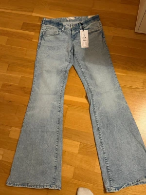 Ljusblå bootcut jeans med utsvängda ben - Säljer ett par ljusblå bootcut jeans med utsvängda ben. Jeansen är lågmidjade  och är i modellen tall.