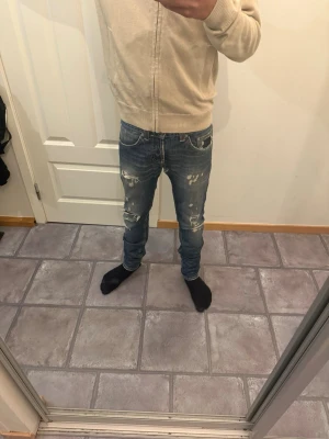 Dondup jeans 29 - Säljer ett par blå jeans från Dondup med slitningar och distressed detaljer på både fram- och baksida, storlek 29 