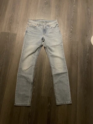 Ljusblå jeans Levi's - Säljer ett par ljusblå jeans från Levi's med klassisk femficksmodell och raka ben. Jeansen har en vintage tvätt och detaljer i silverfärg vid fickorna. Materialet är denim i bomull och passformen är normal med hög midja.