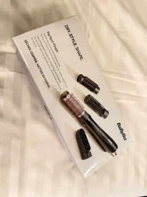BaByliss varmluftsborste set - BaByliss varmluftsborste med flera utbytbara borsthuvuden och munstycke. Borstarna är svarta med metalliska detaljer och handtaget är svart. Perfekt för att torka, styla och forma håret enkelt hemma. Passar alla hårtyper och ger ett proffsigt resultat.