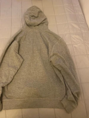 Grå hoodie från U.S. Polo Assn. - Snygg grå hoodie från U.S. Polo Assn. i storlek XS. Klassisk modell med huva och svarta dragsnören. Tillverkad i mjukt sweatshirtmaterial som är perfekt för chill dagar. Enkel och stilren design utan tryck eller mönster.