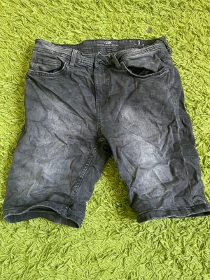 Svarta jeansshorts med fem fickor - Snygga svarta jeansshorts med klassisk femficksdesign och bälteshällor. Modellen har normal passform och är tillverkad i denim med en något tvättad look. Perfekta för en avslappnad stil under varmare dagar.