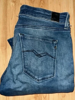 Replay jeans  - Snygga Repaly jeans i blå tvätt med en skinny passform. Midja 35cm, längd 104cm. Obs en gul liten fläck bak på ena byxbenet. JAG SKICKAR EJ FLER BILDER NÄR JAG BÄR JEANSEN! för bättre inblick i passformen rekommenderar jag att googla på modellnamnet. För storleksguide kolla måtten noggrant då jeansen alltid kan vara uppsydda heller krympta och jag ej tar emot returer :) (r17)