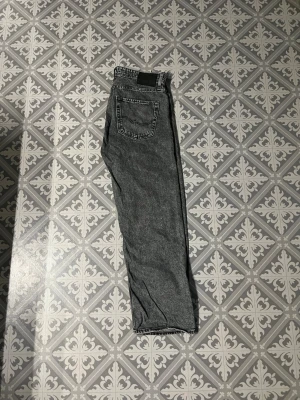 Grå tvättade raka jeans - Säljer ett par grå tvättade jeans från Jack and Jones. Skit snygga nu till hösten 🍁. Storlek W32 och L 32👍