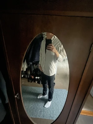 Randig vit skjorta med knappar - Säljer en vit skjorta med tunna, ljusa ränder och klassisk krage. Skjortan har långa ärmar och knäppning framtill. Passar även till vardaglig klädsel, såsom jeans.