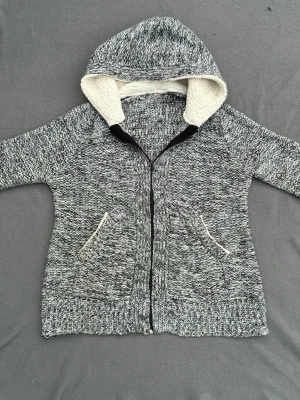 Stickad hoodie - Snygg stickad cardigan / hoodie  med foder i luvan och fina detaljer. Perfekt mot hösten. Fint skick. Storlek M/S.