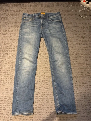 Blå jeans från Jack & Jones - Snygga blå jeans från Jack & Jones med klassisk femficksdesign och raka ben. Jeansen har en lätt tvättad look och är tillverkade i denim. Perfekta för en avslappnad stil. Snygg tvätt! Vintage!