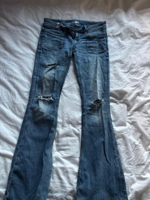 Lågmidjade jeans gina - Populära lågmidjade jeans från gina tricot med hål. Bekväma och i fint skick, säljer pga lite för korta skulle säga de passar folk runt 160-170
