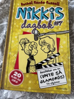 Nikkis dagbok #7 (Modernista) - Nikkis dagbok #7 av Rachel Renée Russell är en färgglad och rolig bok med gul och turkos framsida. Boken handlar om Nikki och hennes äventyr som (inte så glamorös) TV-stjärna. Perfekt för dig som gillar humor och dagboksberättelser.