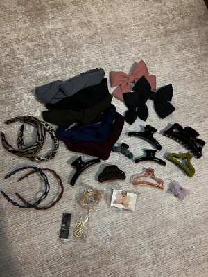 Stort paket håraccessoarer mix - Säljer ett stort paket med håraccessoarer: flera hårklämmor i olika färger och former, hårband i tyg (blå, grön, grå, vinröd), diadem med djurmönster, plastdiadem, stora rosetter i rosa och svart samt små hårspännen. Perfekt för dig som vill variera din hårstyling!