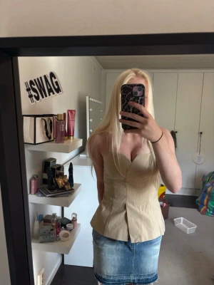 Beige korsettopp med tunna axelband - Säljer en beige korsettopp från Zara som inte kommit till användning med tunna axelband och små ränder. Toppen har en v-ringad formad byst och figurnära passform som ger en snygg siluett. Perfekt att styla med jeans eller kjol! 