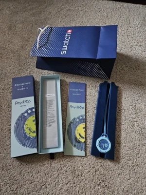 APx Swatch Lan Ba Royal Pop klocka - Säljer en Audemars Piguet x Swatch Lan Ba Royal Pop klocka i blått med cool design och rund urtavla. Klockan har ett blått band och levereras i originalförpackning med tillhörande broschyr och påse. Perfekt för dig som gillar unika accessoarer!