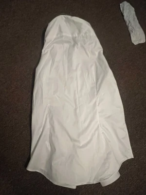 Vit slim fit skjorta från Dressmann - Klassisk vit skjorta från Dressmann Premium i slim fit-modell. Skjortan är tillverkad i ett slätt material och har en stilren design med krage och knappar framtill. Perfekt för en clean och uppklädd look.