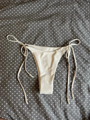 Bikinidel Bikbok helt ny - Helt nya och oanvända bikinitrosor från Bikbok med pärldetaljer på snörena💗 Med hygienklistermärket kvar.  Jag skickar snabbt!