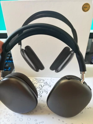 Trådlösa over-ear hörlurar grå - Snygga trådlösa over-ear hörlurar i matt grå färg med mjuka öronkuddar i mesh-tyg och justerbart huvudband. Hörlurarna har en modern design med metallbågar och stora kåpor som omsluter öronen för bra ljudisolering.