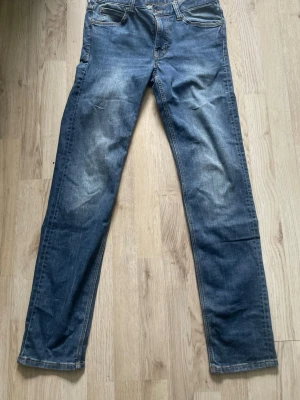 Blå jeans cheap monday - Säljer ett par klassiska blå jeans med raka ben och lätt slitna detaljer. Jeansen har fem fickor och normal midja. Perfekta för en avslappnad och stilren. Storlek 28/32