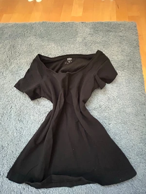 Svart basic t-shirt med rund hals - En enkel svart t-shirt med rund halsringning och korta ärmar. Tillverkad i mjukt bomullstyg som är skönt mot huden. Perfekt att matcha med jeans eller kjol för en clean och stilren look.