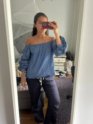 Blå offshoulder blus med volangärmar - Trendig blå offshoulder blus i lätt bomullstyg med vida, volangprydda ärmar. Blusen har en avslappnad passform, så snygg🩵🩵