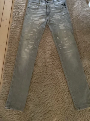 Grå slitna jeans från Replay - Säljer ett par grå jeans från Replay. Storlek 28 och modell Anbass. Pris går att diskuteras!!