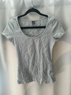 T-shirt med urringning  - En grå T-shirt med urringning🩷