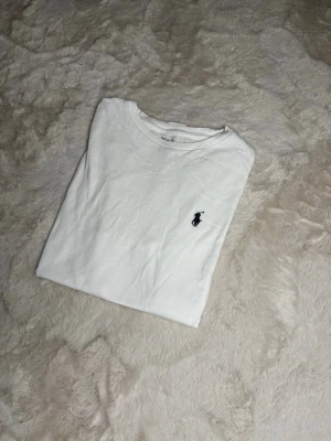 Vit ralph lauren t-shirt - Säljer en väldigt fin ralph lauren t-shirt då den är nästan som ny, har använd den fåtals gånger då den är som ny. T-shirten har ej några fläckar eller täcken på användning. Kom gärna privat för mer info eller bilder på T-shirten!