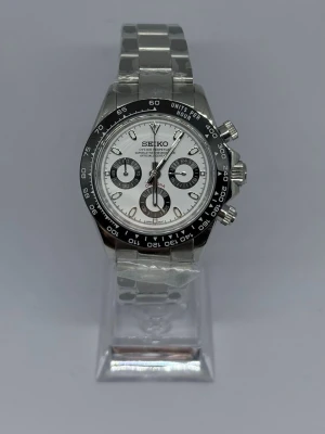 Seiko Mod Daytona ”Panda” - Stilren Seiko Mod Daytona med silverfärgad länkarmband och vit urtavla. Klockan har svarta detaljer runt urtavlan och tre mindre subdials. Boetten och armbandet är i metall. Glaset är gjort av Safir! Perfekt för dig som gillar en sportig men klassisk look. Skriv om ni har några frågor!