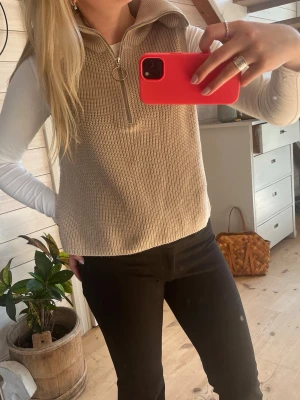 Beige stickad väst med dragkedja - Snygg beige stickad väst med halv dragkedja framtill