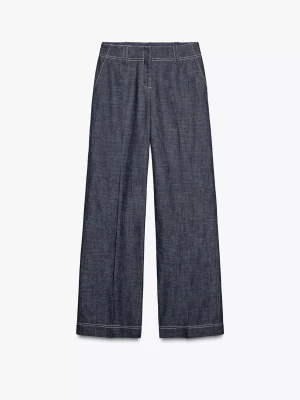 Mörkblå vida jeans med kontrastsömmar - Säljer ett par mörkblå jeans med raka, vida ben och vita kontrastsömmar. Jeansen har hög midja, bälteshällor och klassisk femficksdesign. Materialet är denim i bomull och passformen är avslappnad och trendig.