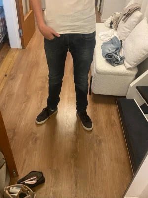 Mörkblå slim fit jeans herr - Säljer ett par mörkblå slim fit jeans från Replay med snygga slitningar och klassisk femficksmodell. Jeansen har en smal passform och är tillverkade i stretchigt denimtyg för extra komfort. Perfekta till sneakers och t-shirt för en avslappnad look. Nypris 1200