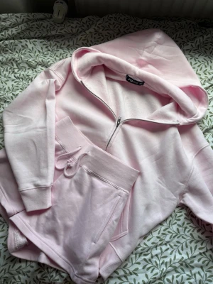 Ljusrosa loungewear-set FB Sister - Mysigt loungewear-set i ljusrosa från FB Sister. Setet består av en hoodie med dragkedja och huva samt matchande shorts med dragsko och fickor. Perfekt för chill dagar både ute och hemma eller när du vill vara extra bekväm. Passar storlekar XXS/XS/S även M om du vill ha den lite tightare!