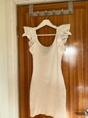 Vit kortklänning med volangärmar - En vit kortklänning från h&m i storlek S. Den är endast provad så mycket fint skick!!⭐️