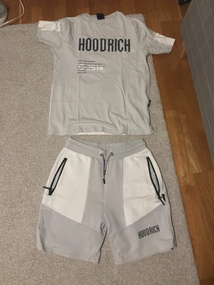 Ljusgrå kortärmad t-shirt Hoodrich - PRISET GÄLLER FÖR HELA SETET, skriv om ni vill köpa enbart t shirten eller shortsen. Grått set från Hoodrich med matchande t-shirt och shorts. Tryck på båda sidor. Mycket bra skick. 