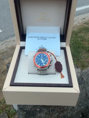 Omega Seamaster Planet Ocean Chronograph – komplett set med box & tillbehör - Omega Seamaster Planet Ocean Chronograph i mycket fint skick. Kommer med box, manualer, Omega-hållare, chronometer-certifikat, hangtag och övriga tillbehör enligt bilderna. Säljs med allt som syns på bilderna. 