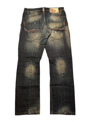 Vintage faded distressed patched Jack & Jones jeans - Säljer ett par super unika jeans med fet fader och distress, med rak passform som lägger sig sjysst på skorna. Måtten är följande: waist 42 cm, totala längd 104,5 cm och benöppning 21 cm
