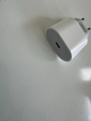 Vit USB-C väggladdare - Säljer en vit USB-C väggladdare med två runda stift för europeiska eluttag. Laddaren har en kompakt och stilren design i plast och passar perfekt för att ladda mobilen eller surfplattan snabbt och smidigt.