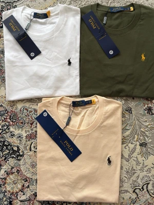3-pack t-shirts från Polo Ralph Lauren - Säljer ett 3-pack t-shirts från Polo Ralph Lauren alla för 900kr i färgerna vit, olivgrön och beige. Alla har den klassiska broderade loggan på bröstet och är gjorda i mjuk bomull. Perfekt basic-plagg med normal passform och korta ärmar.