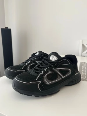 Svarta B30 sneakers - Säljer ett par svarta B30 sneakers med coola grå och vita detaljer. Skorna har en chunky sula, meshpaneler och reflekterande inslag på sidan. Klassisk snörning och bekväm passform. Perfekta för dig som gillar streetwear.