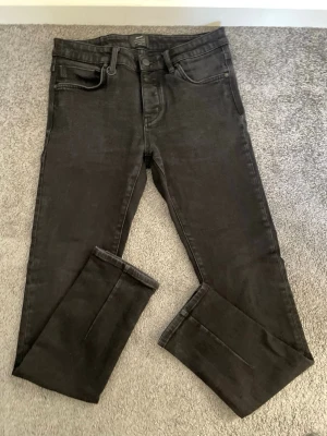 Svarta jeans från Neuw - Snygga svarta jeans från Neuw med klassisk femficksmodell och raka ben. Jeansen har en stilren look och är tillverkade i ett mjukt denimtyg som ger en bekväm känsla. Perfekta för dig som gillar en enkel men trendig stil.