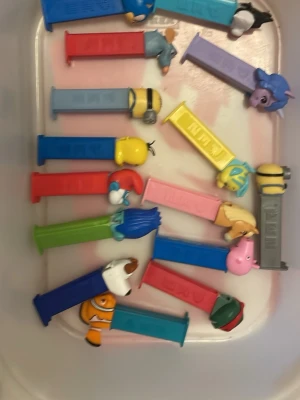 Samling PEZ-figurer - Säljer en samling PEZ-godisautomater med olika färger och motiv från kända karaktärer som Minions, Sonic, My Little Pony, Nemo och fler. Perfekt för dig som gillar samlarprylar eller vill ha något kul till godiset. Alla automater är i plast och har färgglada detaljer.