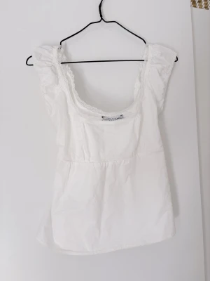 Vit blus Brandy Melville - Vit blus med spetsdetaljer och knytband. Står ingen storlek i plagget, men skulle säga xs-s. 