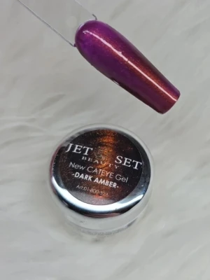 Jet Set Cat Eye Gel Dark Amber - Magnetiskt cat eye color gel från Jet Set Beauty i färgen Dark Amber. Lacket har en skimrande finish med en mix av lila och bärnstensbruna toner som ger en cat eye effekt 